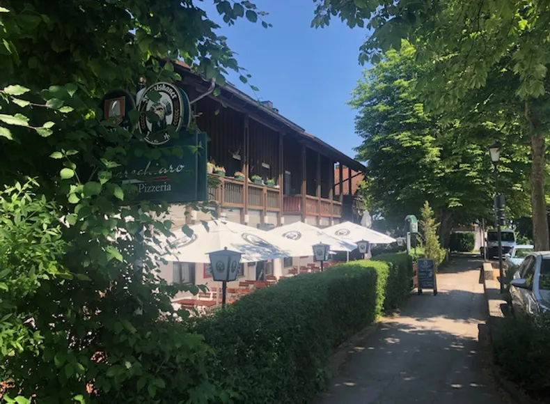Pizzeria Marechiaro Seestrasse Prien Von Aussen mit gemütlichem Biergarten/Terrasse , weissen Sonnenschirmen und viel Grün drum rum