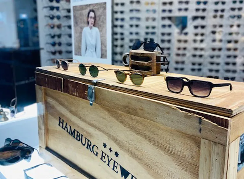 Auf einer Holzkiste werden Sonnenbrillen von Hamburg Eyewear prästentiert.