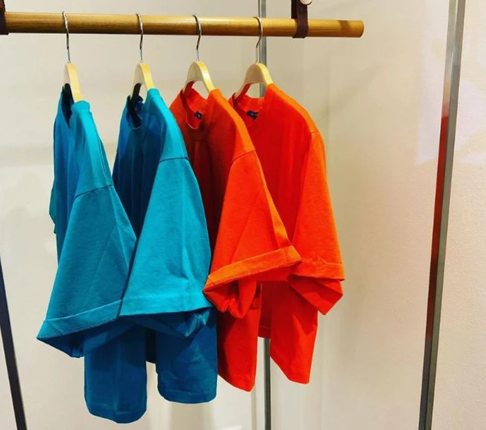 Damen-T-Shirt hängen auf einer Stange in den Farben blau und orange