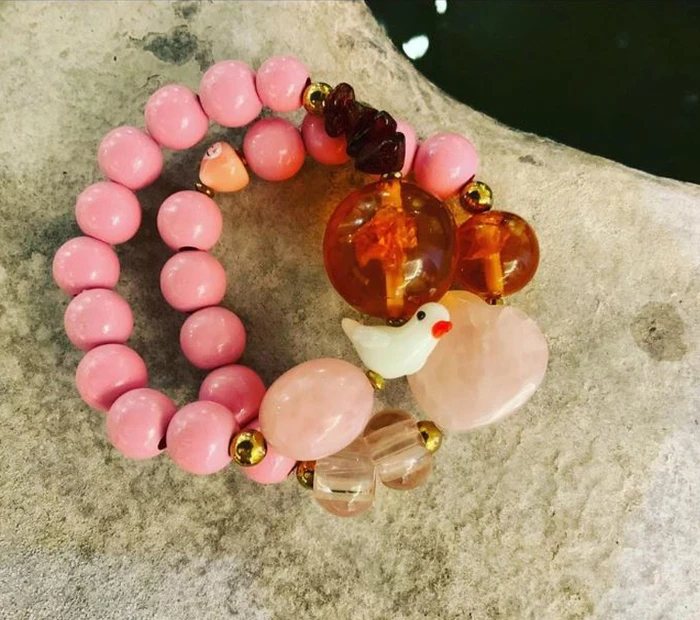 Modeschmuck-Armband in rose mit Perlen.