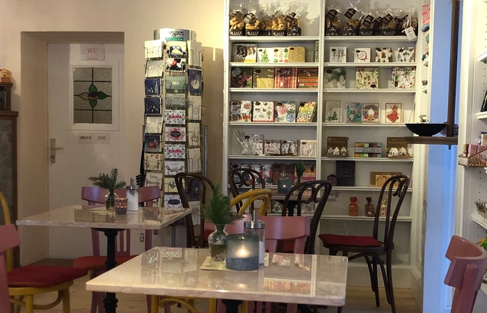 Blick in das Cafe Villino, im Hintergrund sieht man einen Ständer mit Karten und ein Regal mit Servietten.