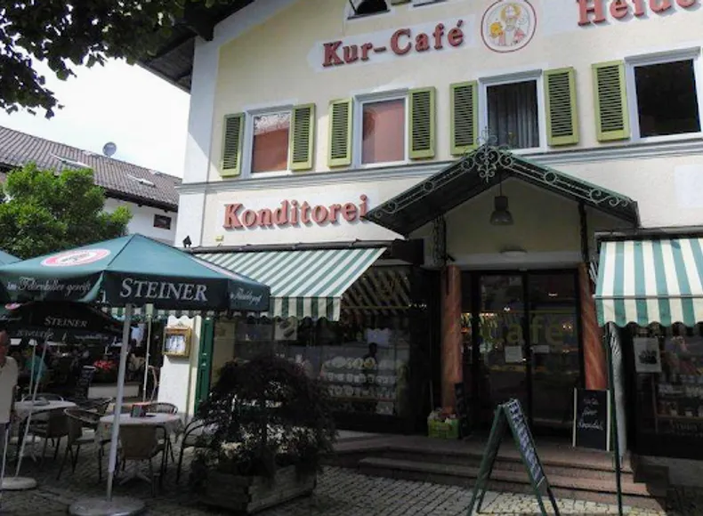 Aussenfassade des Traditionskonditors und Kurcafe Heider am Marktpletz in Prien neben der Kirche mit gemütlicher Terrasse Wintergarten und 2 Cafe-Räumen. riesieger Kuchentheke und mega auswahl an Pralinen