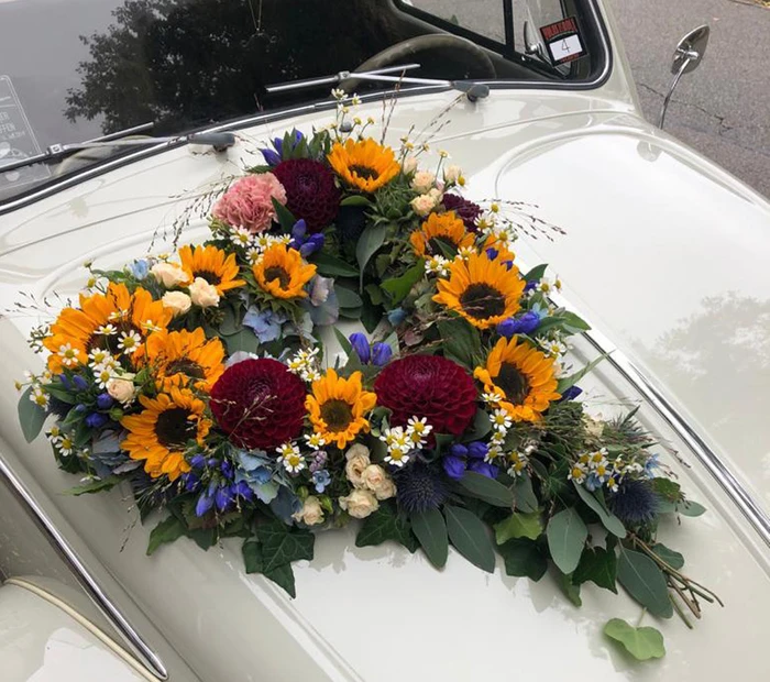 Hochzeitsauto mit einem Blumen-Bouquet in Herzform