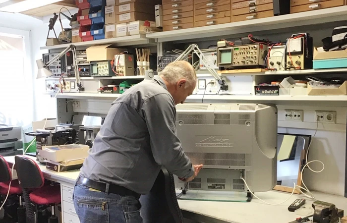 Sebastian Aicher repariert ein TV-Gerät von Metz in der Werkstatt von Kiefl Electronik Prien