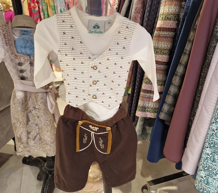Abgebildet ist eine Trachten-Babykombi in braun, erhältlich in der Chiceria, solange Vorrat reicht.