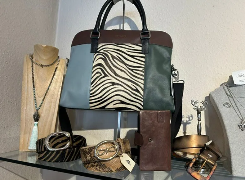 Damenhandtasche groß mittelblau mit Zebra im Wechsel, lange Kette mit Bommel, grauer Gürtel mit Wechselschließe in Silber im rockigen Fashionstore für Damen in Prien in der Seestrasse im Zentrum Priens 